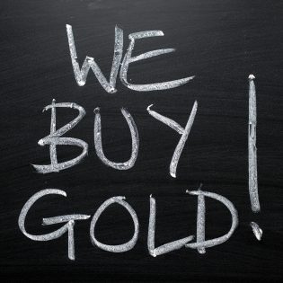 Der Satz "Wir kaufen Gold" wurde von Hand mit weißer Kreide auf eine Tafel geschrieben